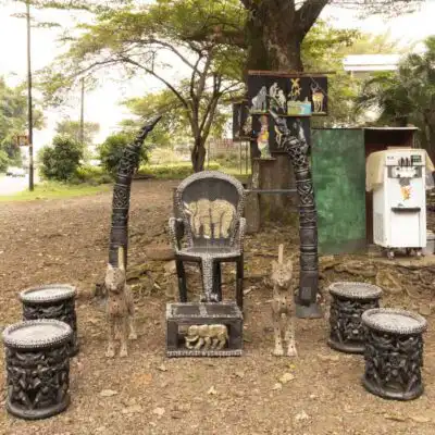 Hand-carved Bamileke Tribe King Throne Set, featuring a king's chair, foot stool, statues, and stools, symbolizing African royalty, available at BaobabMart.